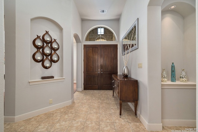 entrance foyer featuring baseboards, visible vents, and light tile patterned flooring