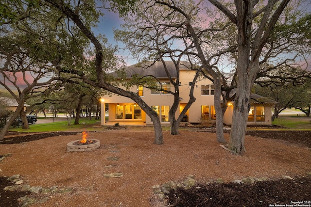 view of front facade with a fire pit and stucco siding