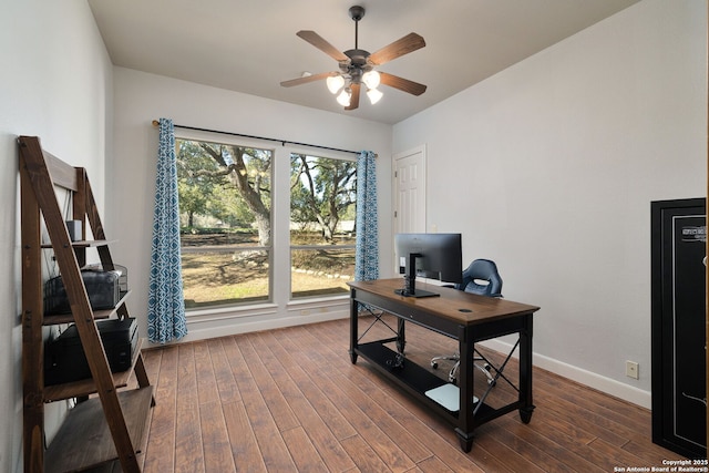 office area featuring dark wood-type flooring, a ceiling fan, and baseboards