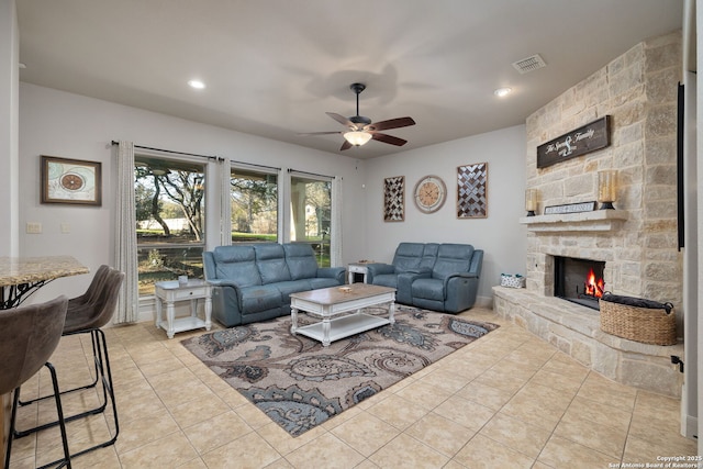 living room with visible vents, a ceiling fan, light tile patterned flooring, a stone fireplace, and recessed lighting