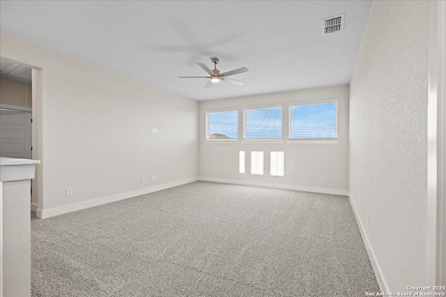 unfurnished room with baseboards, carpet, visible vents, and a ceiling fan