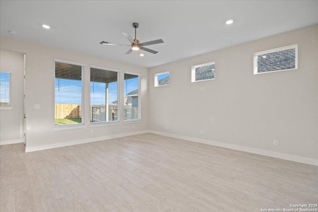 empty room featuring light wood-type flooring, visible vents, baseboards, and recessed lighting