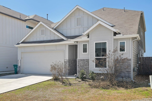 view of front of house with roof with shingles, concrete driveway, an attached garage, board and batten siding, and fence