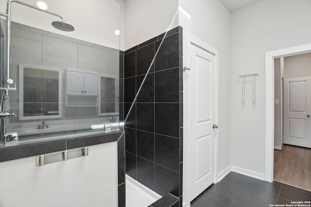 bathroom featuring baseboards, walk in shower, and tile patterned floors