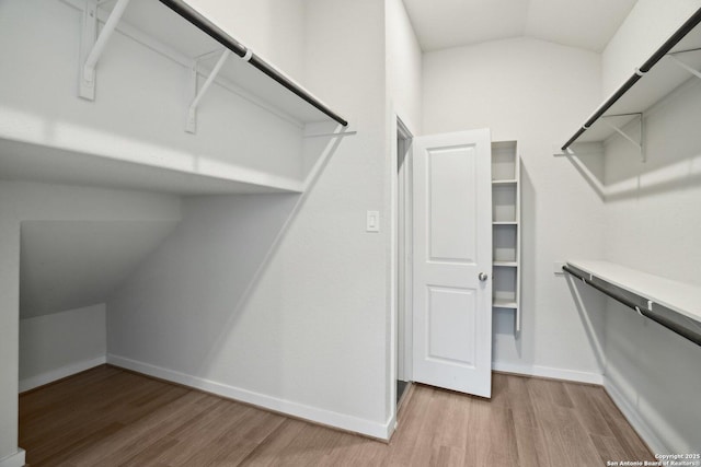 walk in closet featuring vaulted ceiling and wood finished floors