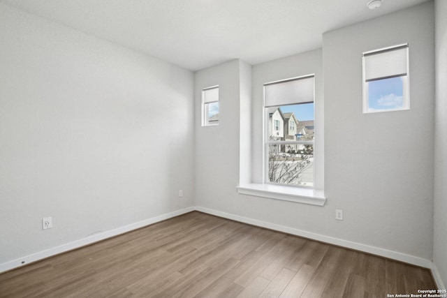 empty room with wood finished floors and baseboards