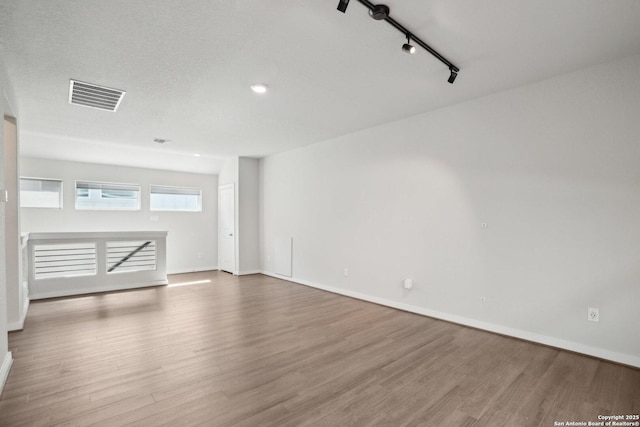 spare room with visible vents, baseboards, and wood finished floors