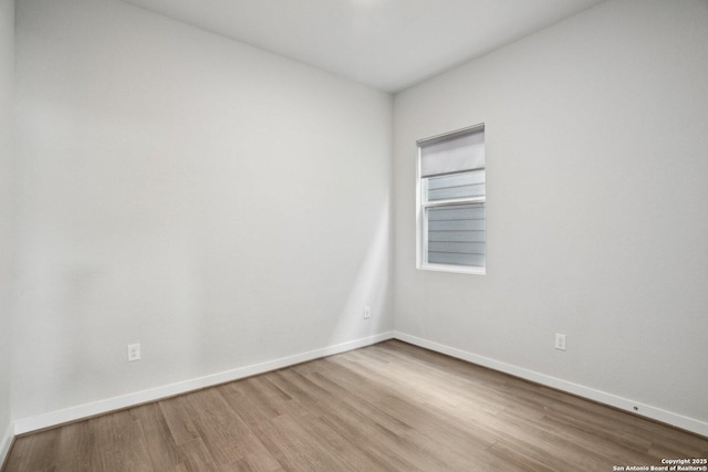 empty room featuring baseboards and wood finished floors