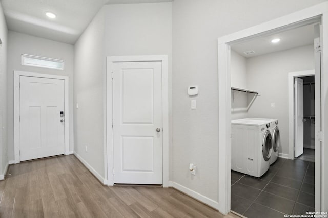 washroom featuring laundry area, baseboards, and washing machine and clothes dryer