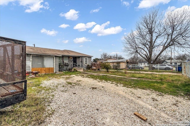 back of property with driveway and fence