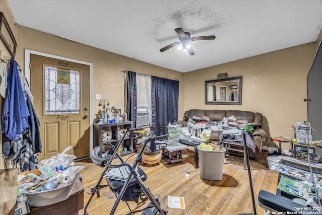 interior space featuring ceiling fan, a textured ceiling, and wood finished floors