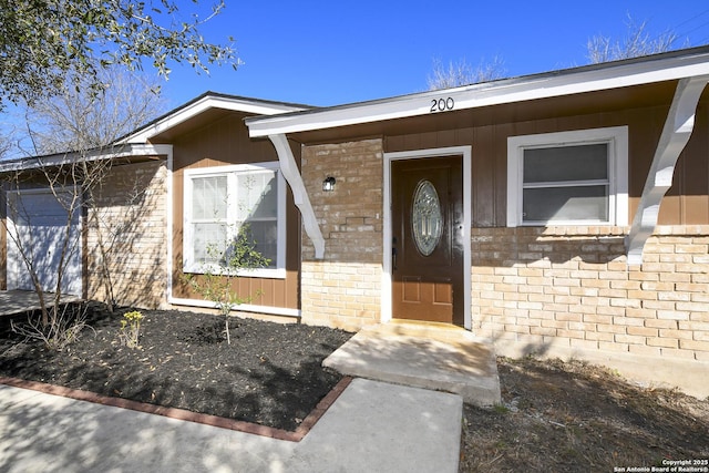 view of exterior entry featuring brick siding