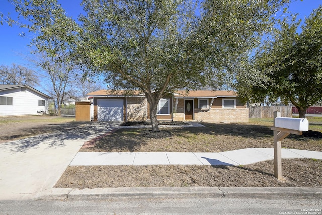 single story home featuring brick siding, driveway, an attached garage, and fence