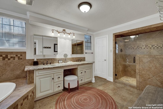 bathroom featuring ornamental molding, a sink, a textured ceiling, and a bath