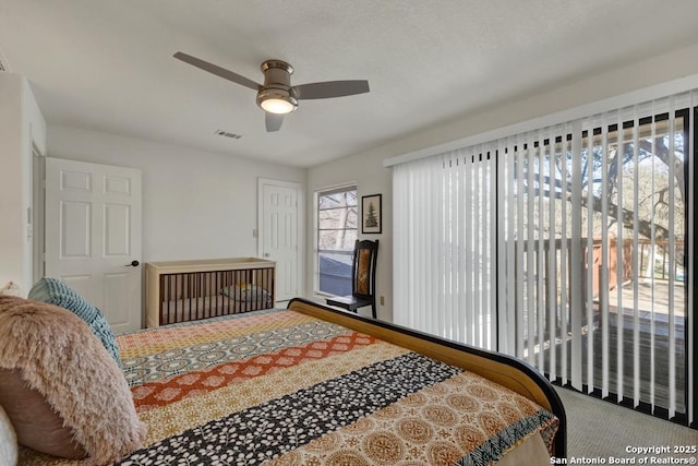 carpeted bedroom featuring visible vents and a ceiling fan