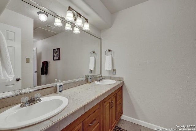 bathroom featuring double vanity, visible vents, a sink, and tile patterned floors