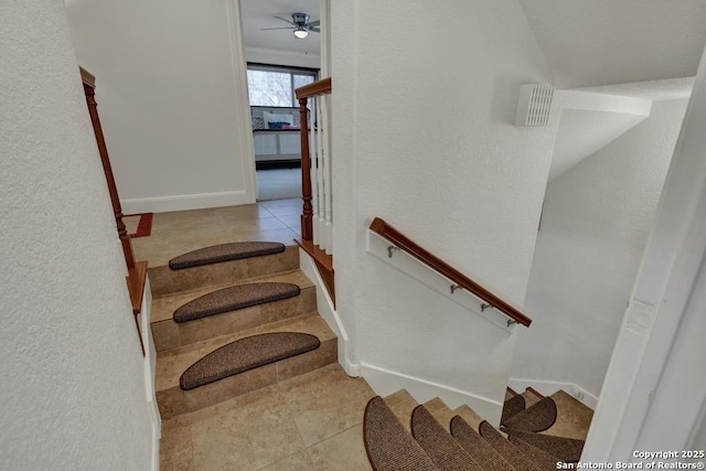 staircase featuring tile patterned flooring, ceiling fan, and baseboards