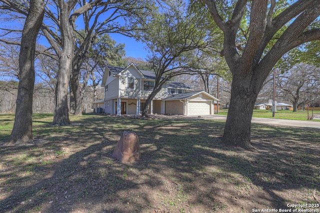 view of front of home with driveway, an attached garage, and a front yard