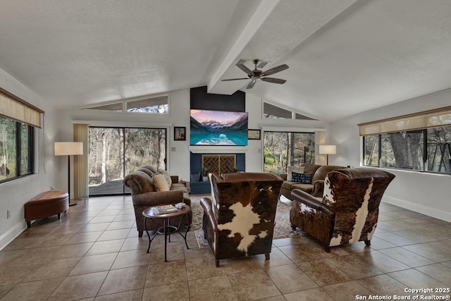 tiled living room featuring vaulted ceiling with beams, a fireplace with raised hearth, a textured ceiling, a ceiling fan, and baseboards