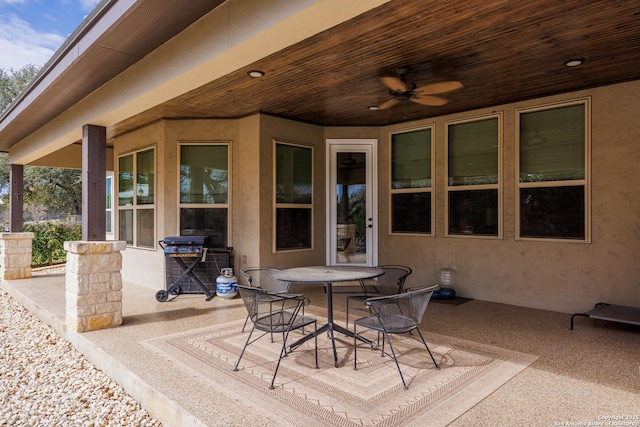 view of patio with outdoor dining area, a grill, and ceiling fan