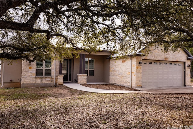 single story home with stone siding and an attached garage