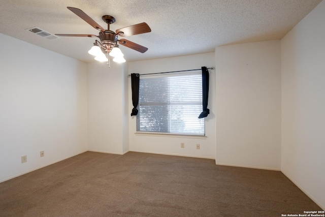 spare room with a ceiling fan, carpet, visible vents, and a textured ceiling