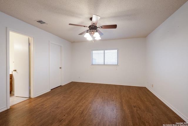 unfurnished bedroom featuring a textured ceiling, wood finished floors, visible vents, and baseboards