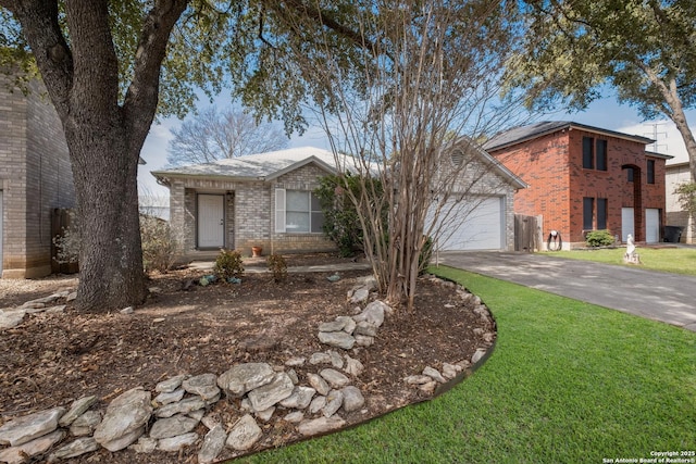 view of front of home featuring a garage, brick siding, driveway, and a front lawn