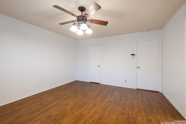 empty room featuring ceiling fan, baseboards, and wood finished floors