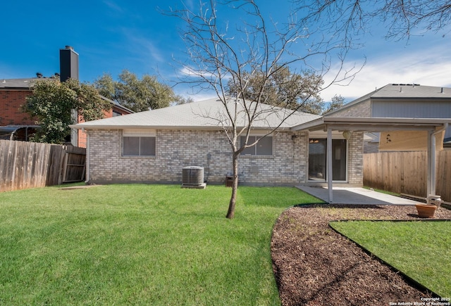 rear view of property featuring a lawn, a fenced backyard, central air condition unit, a patio area, and brick siding