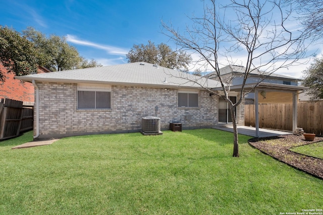 rear view of house featuring a yard, a fenced backyard, and a patio