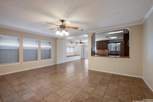 unfurnished living room featuring light tile patterned floors, visible vents, baseboards, a ceiling fan, and crown molding