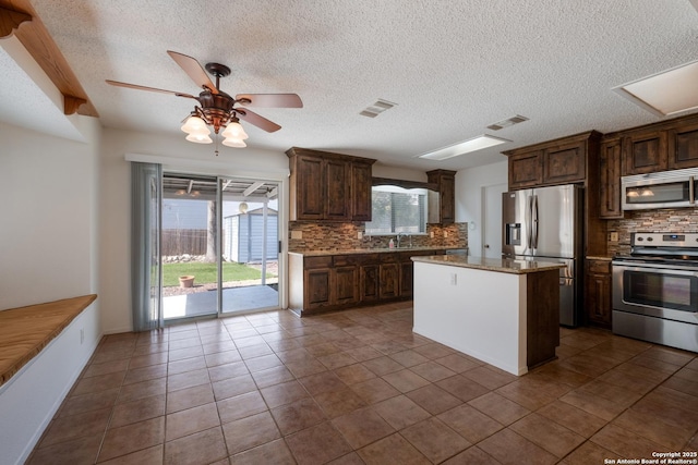 kitchen featuring stainless steel appliances, visible vents, a sink, and tasteful backsplash