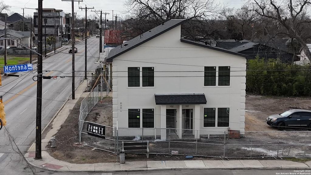 view of front of property featuring fence and stucco siding