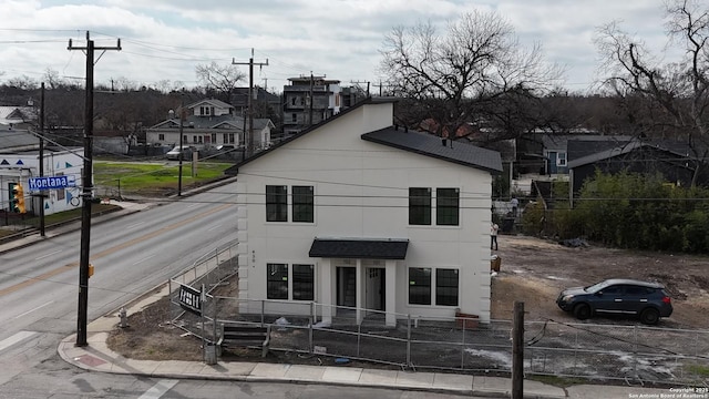 view of front facade with a fenced front yard, a residential view, and stucco siding