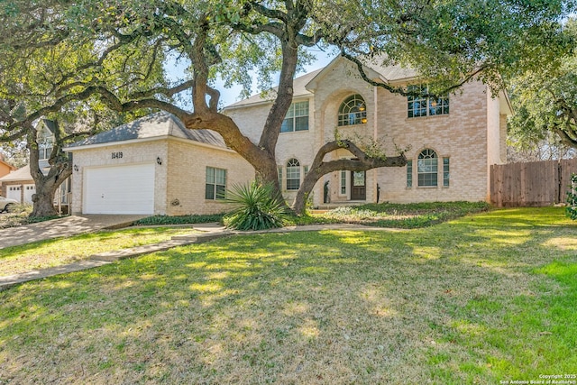 view of front facade with brick siding, an attached garage, fence, driveway, and a front lawn