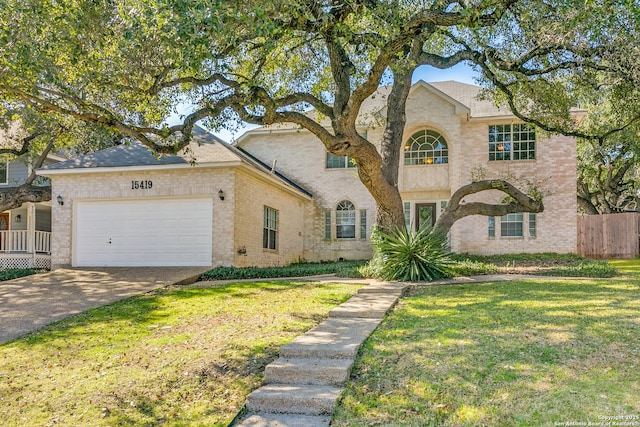 view of front of home featuring brick siding, an attached garage, fence, driveway, and a front lawn