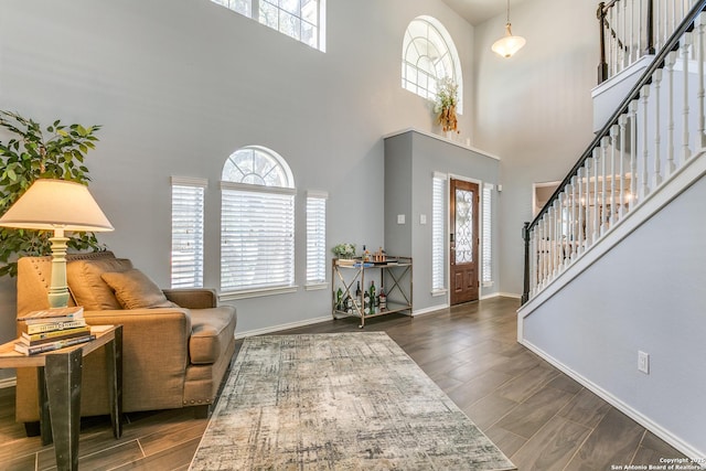 entrance foyer with a wealth of natural light, dark wood finished floors, and stairs