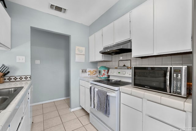 kitchen with white electric range oven, tasteful backsplash, visible vents, tile countertops, and under cabinet range hood