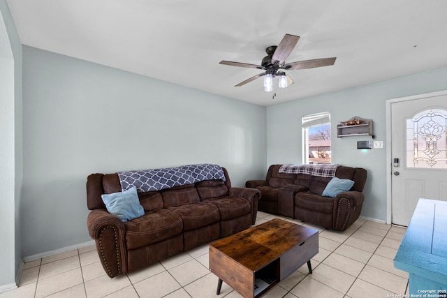 living room with light tile patterned floors, ceiling fan, and baseboards