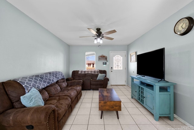 living room with light tile patterned floors, a ceiling fan, and baseboards