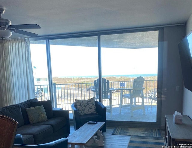 living room featuring a wall of windows and a ceiling fan