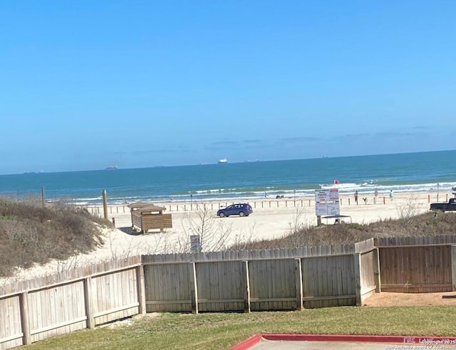 property view of water with a view of the beach and fence