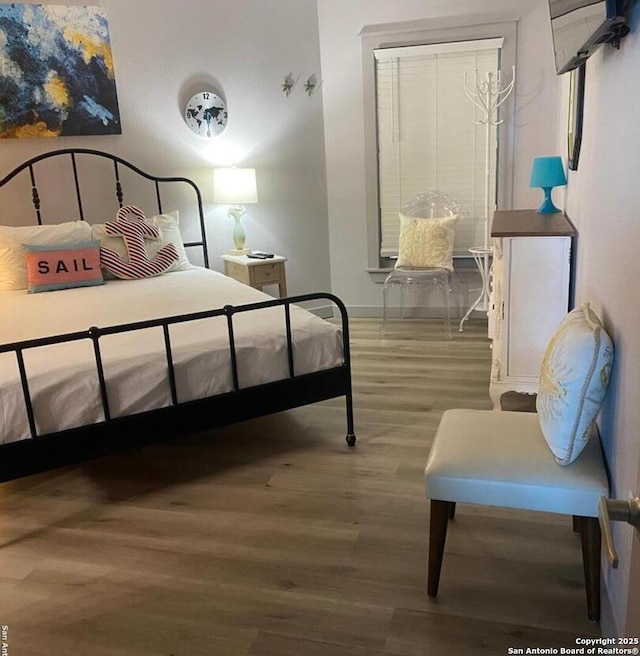 bedroom with baseboards and wood finished floors