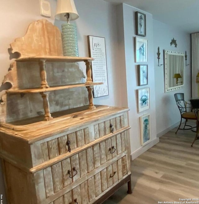 interior space featuring baseboards and wood finished floors