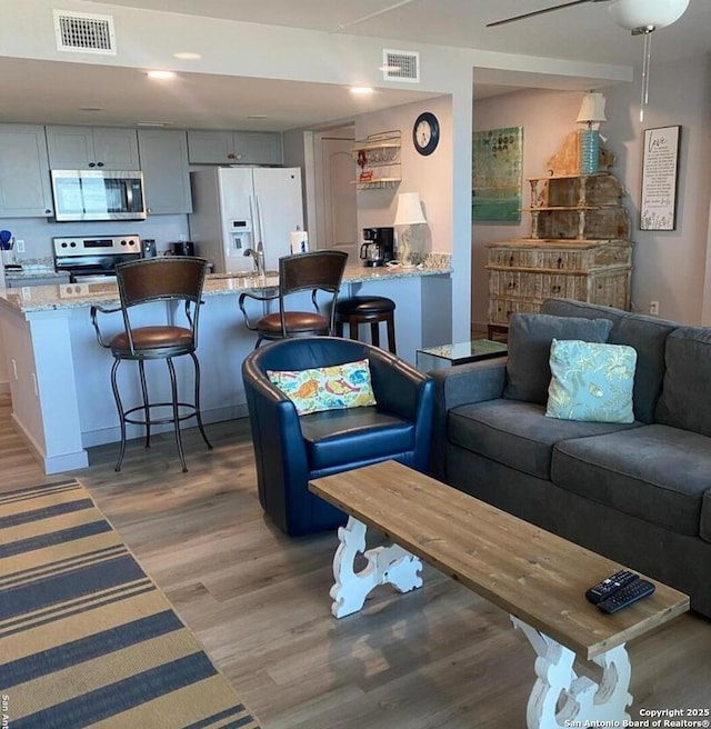 living room featuring visible vents and light wood-style flooring