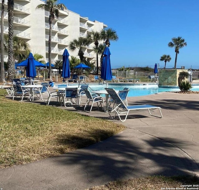 community pool featuring a patio area and fence