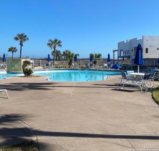 pool featuring fence and a patio