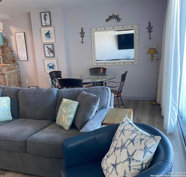 living area with baseboards and wood finished floors