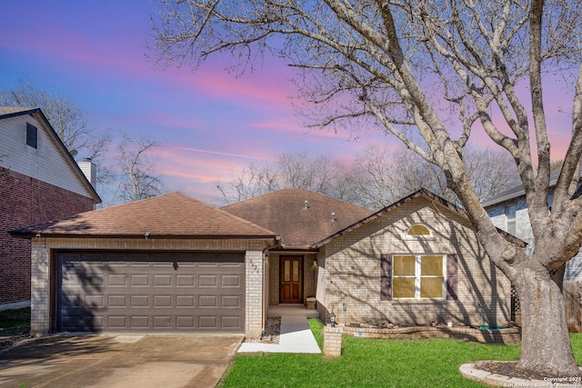 view of front facade featuring brick siding, a yard, a shingled roof, concrete driveway, and a garage